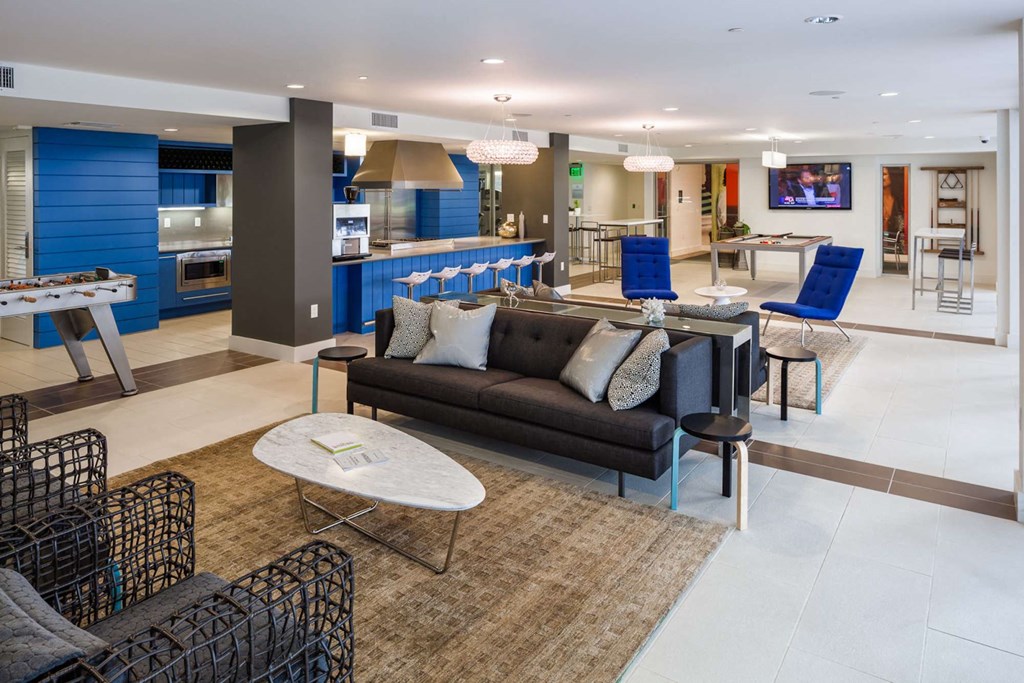 a living room and kitchen with blue chairs and a couch