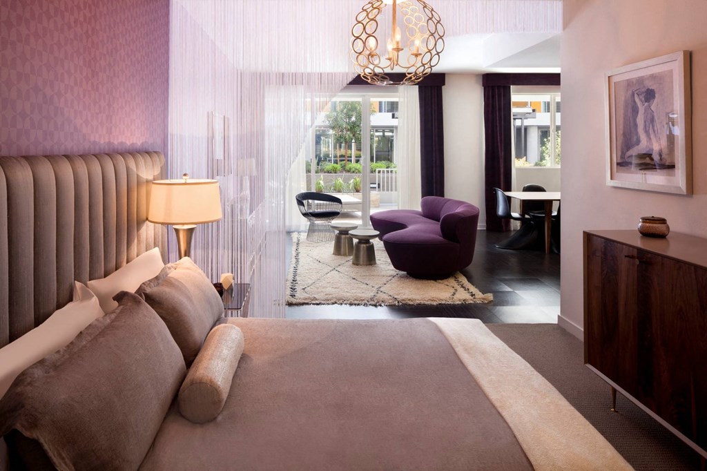 a bedroom with a bed and a living room with a couch and a table