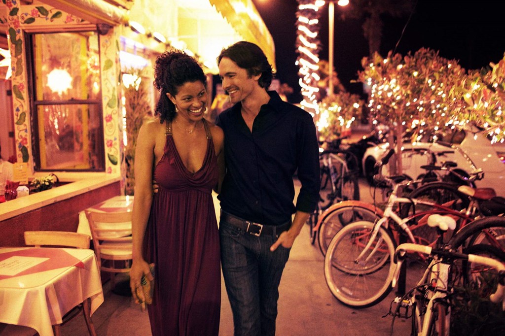 a man and a woman walking down a street at night