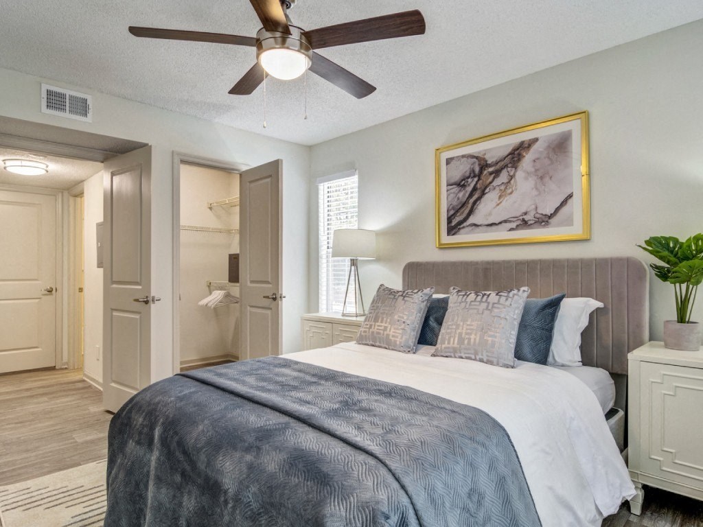 a bedroom with a large bed and a ceiling fan