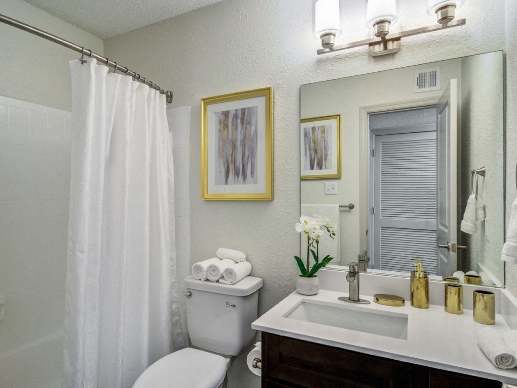 a bathroom with a shower and a toilet and a sink