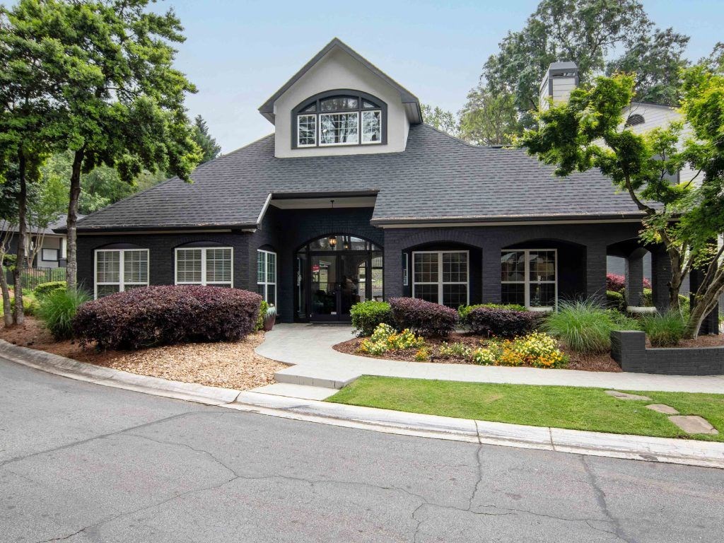 a black house with a sidewalk in front of it