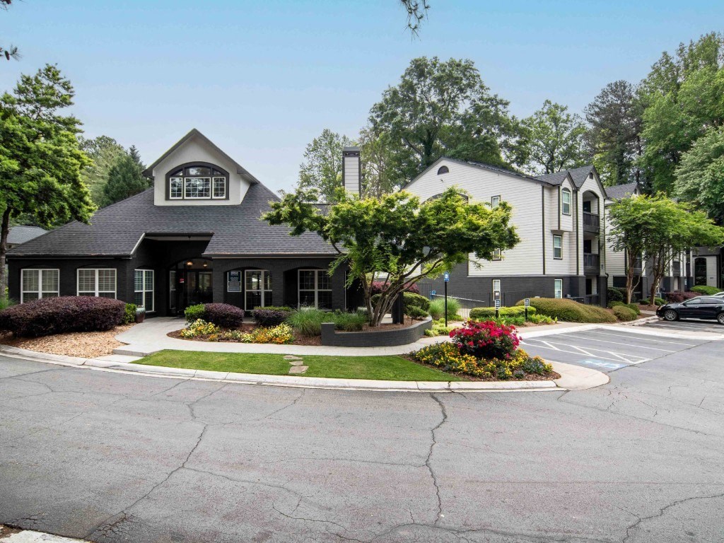 a house with a driveway and a tree in front of it