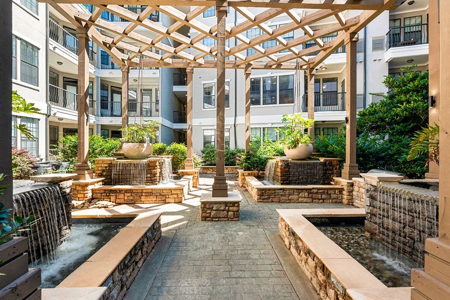 a courtyard with water fountain and seating in an apartment building
