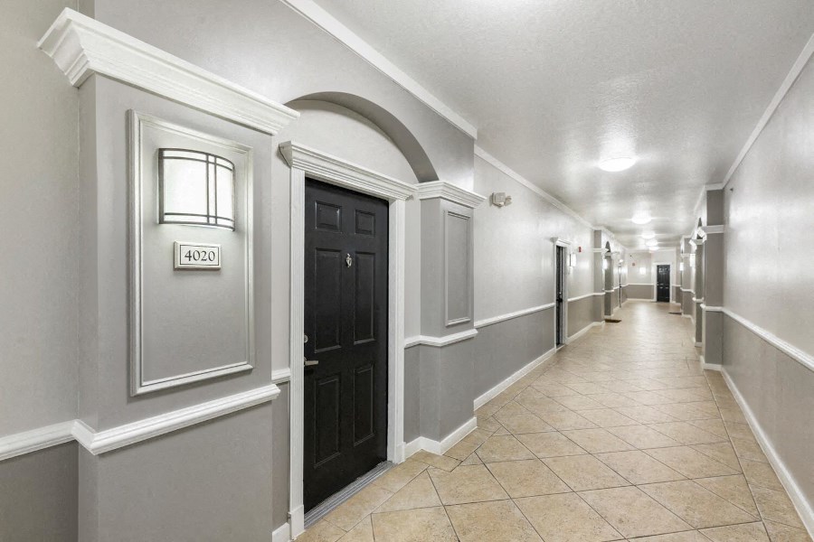 the hallway of a building with a lobby and a black door
