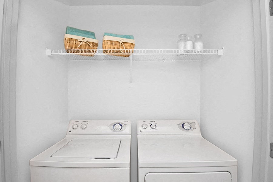 a white washer and dryer in a white laundry room
