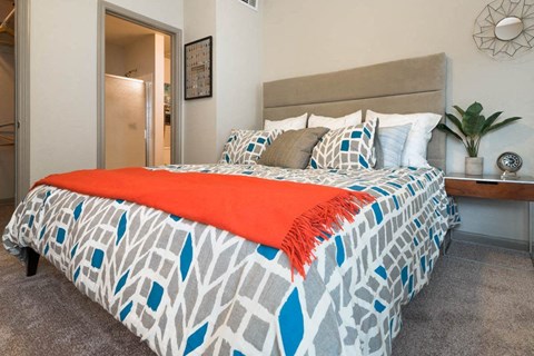 a bedroom with a bed and a potted plant