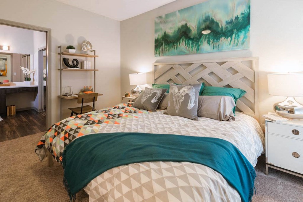 a bedroom with a bed and a painting on the wall