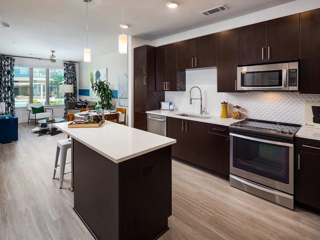 A modern kitchen with dark brown cabinets and a white island.