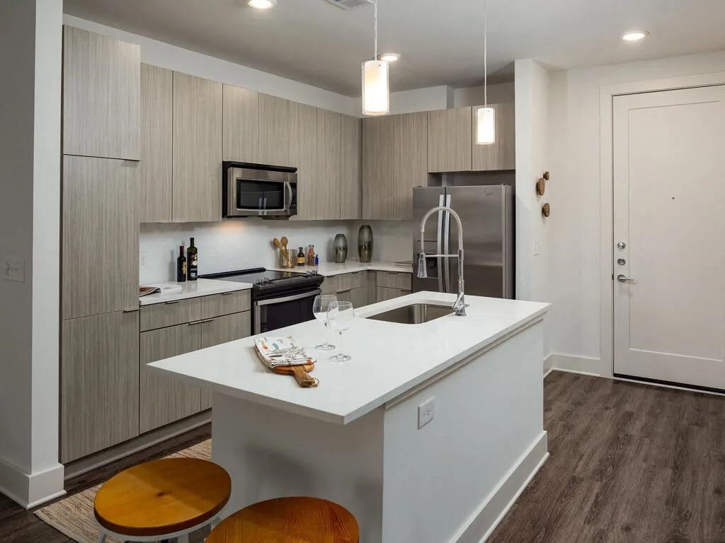 A kitchen with a white island and wooden floors.