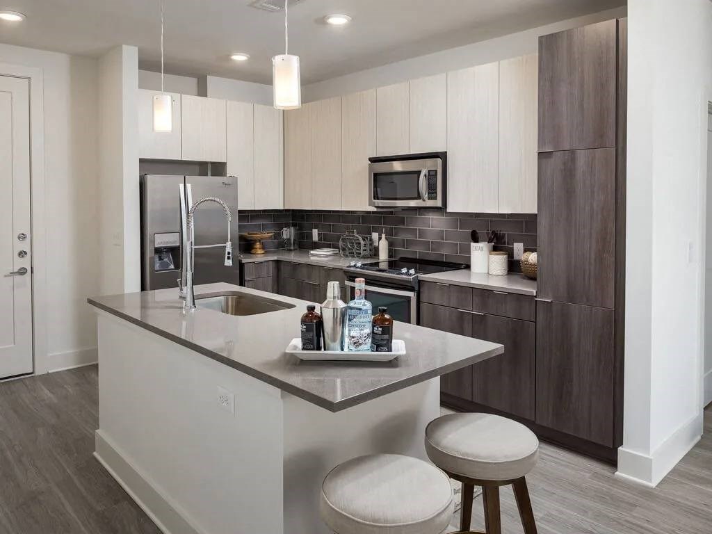 A modern kitchen with a large island and stainless steel appliances.
