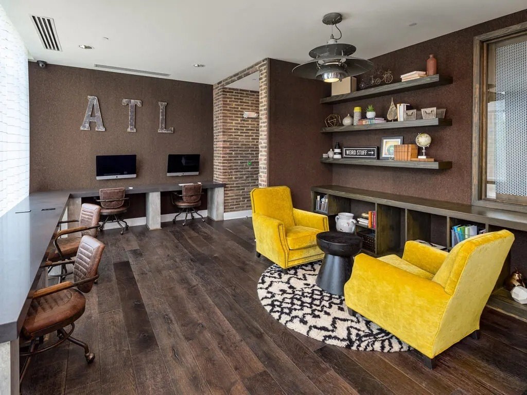 A living room with a yellow chair and a black and white rug.