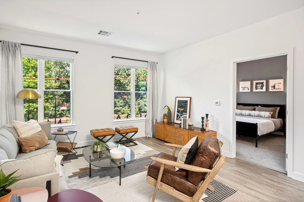 A living room with a couch, chair, and a table with a vase on it.