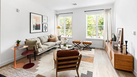A living room with a couch, chair, and a table with a plant on it.