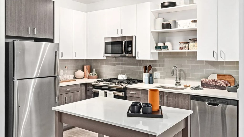 A modern kitchen with a stainless steel refrigerator and white countertops.