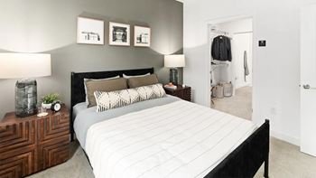 A bedroom with a large bed and a wooden dresser.