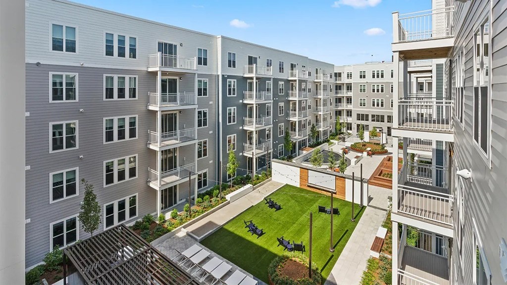 A modern apartment complex with a central courtyard and landscaping.