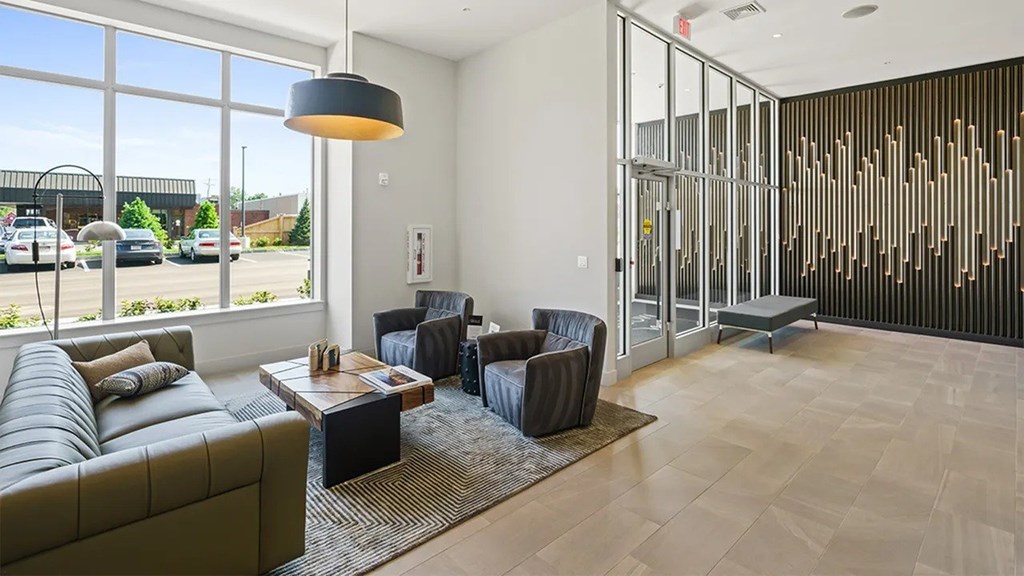 A modern living room with a large window overlooking a parking lot.