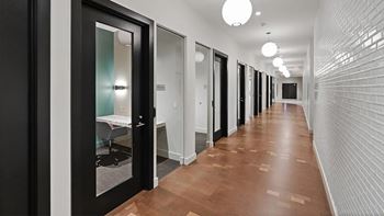 A long hallway with doors on both sides and a light on the ceiling.