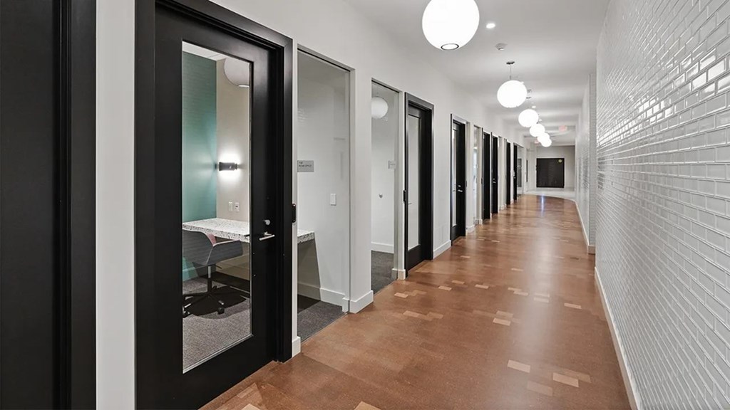 A long hallway with doors on both sides and a light on the ceiling.
