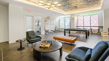 A living room with a variety of seating options including a black leather chair, a blue fabric chair, and a wooden bench.