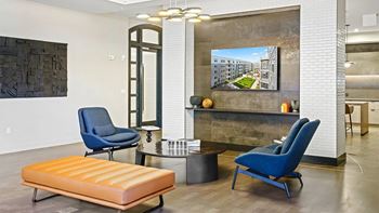 A living room with a blue chair and a wooden bench.