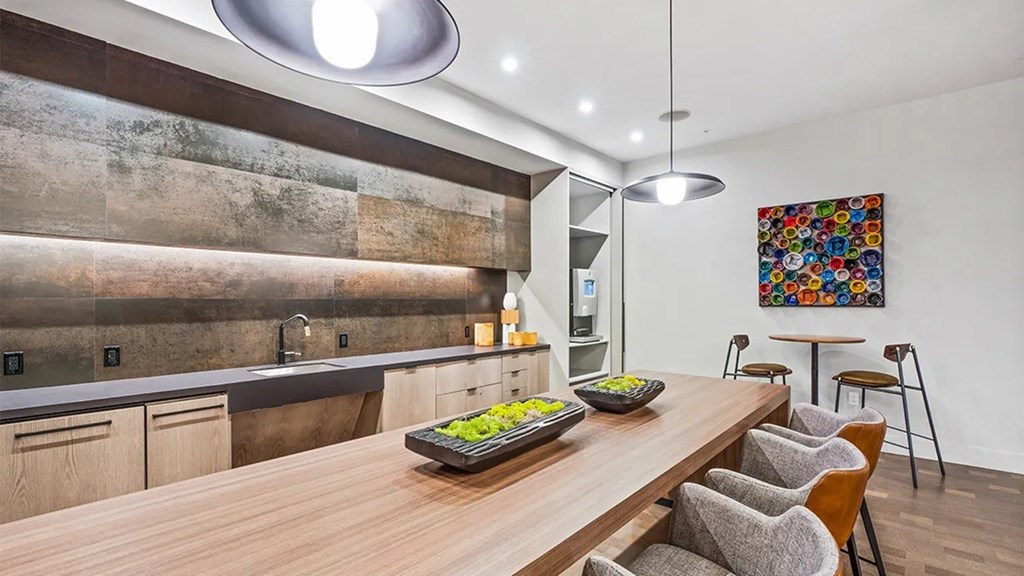 A modern kitchen with a wooden table and chairs.