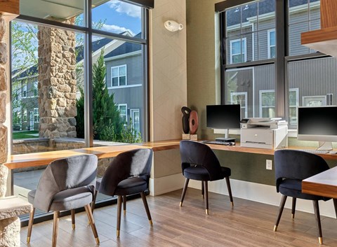 A room with a stone pillar and a desk with chairs.