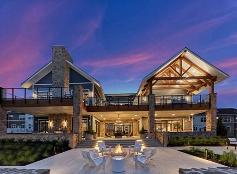 A modern house with a stone chimney and a large glass window.