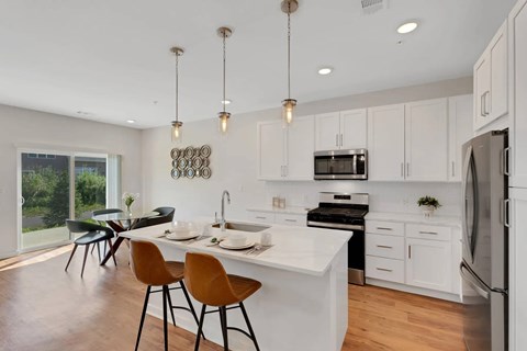 A modern kitchen with white cabinets and a large island.
