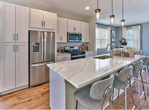 A modern kitchen with a large island and stainless steel appliances.