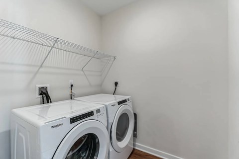A Whirlpool washing machine and dryer in a laundry room.