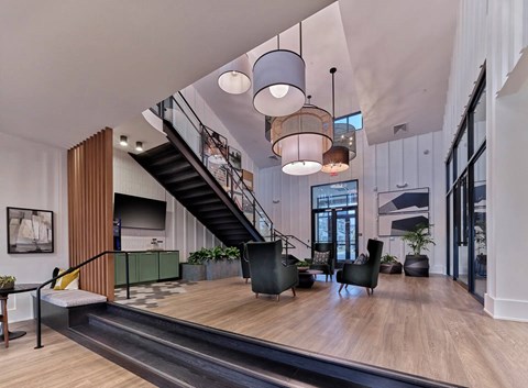 A modern living room with a staircase and a large window.
