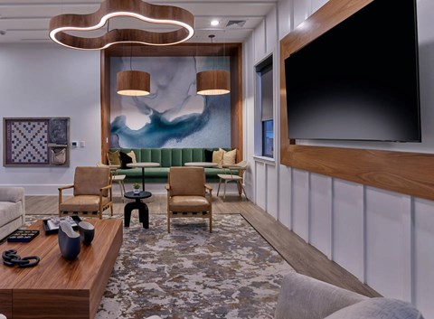 A modern living room with a large painting, a sofa, a coffee table, and a TV.