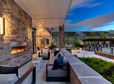 A patio with a stone fireplace and seating area.