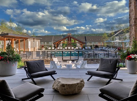 A patio with chairs and a table with a stone top.