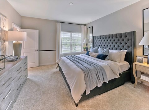 A bedroom with a large bed and a dresser.