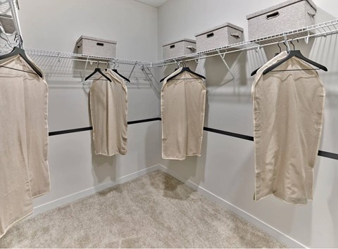 A row of towels are hung on a rack in a room.