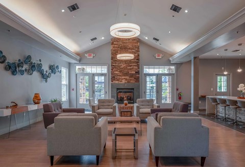 A large room with a fireplace and chairs.