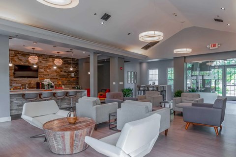 A modern living room with a stone wall and a variety of seating options.