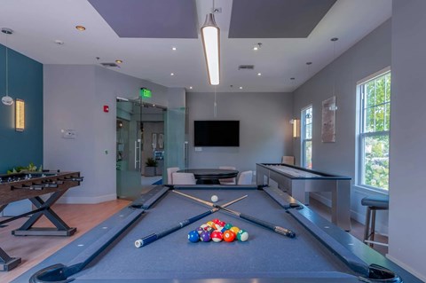 A room with a pool table and a TV.
