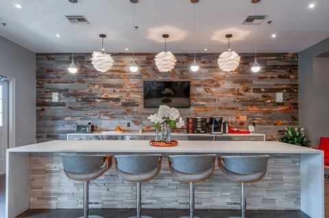 A modern kitchen with a bar area and a stone backsplash.
