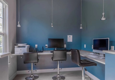 A modern office with two chairs and two monitors.