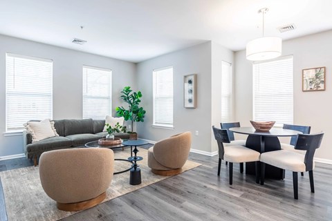 A living room with a grey couch, a coffee table, and a dining table with chairs.