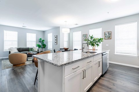 A modern kitchen with a large island and a seating area.