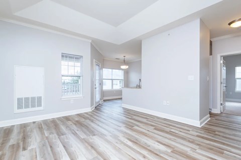 A spacious room with wooden flooring and white walls.