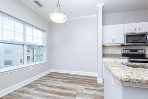 A kitchen with a microwave oven built into the cabinetry.