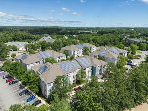 A bird's eye view of a residential area with houses and solar panels on the roofs.