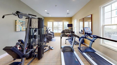 A spacious gym with treadmills, elliptical machines, and other exercise equipment.
