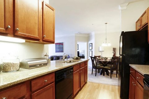 A kitchen with wooden cabinets and a black refrigerator.